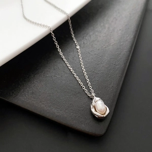 Minimalist French style necklace featuring irregular silver pendant with freshwater pearl