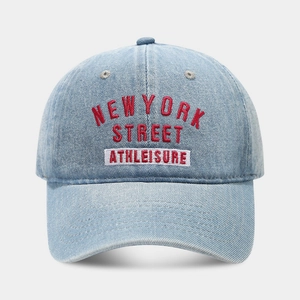 Close-up of red New York Street embroidery and white patch on light blue denim baseball cap