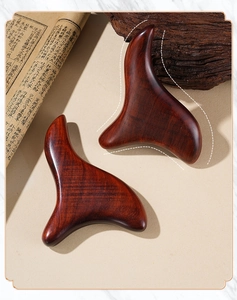 Macro detail of sandalwood triangular massager with natural grain and ergonomic design