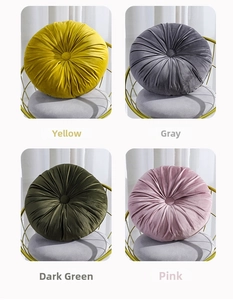 Detail view of round velvet pumpkin pillows in yellow, gray, green, and pink colors