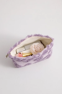 Close-up of soft purple plush makeup bag with interior lining and cosmetics storage