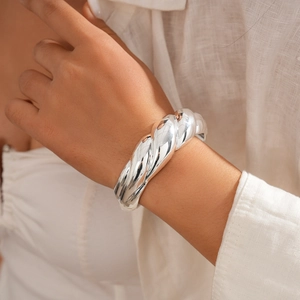 Detailed view of silver twisted rope cuff bracelet worn by model showing texture