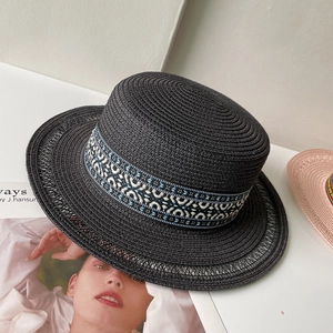 Dettaglio cappello di paglia nero con nastro geometrico blu e bianco e trama intrecciata
