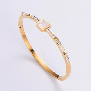 Detail view of 18K gold plated bangle featuring square mother of pearl and zircon stones