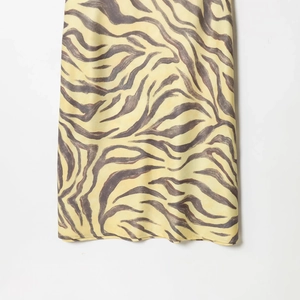Elegant sleeveless dress featuring a yellow and dark brown zebra animal print pattern