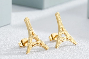 Gros plan de boucles d'oreilles clous tour Eiffel dorées en acier inoxydable poli