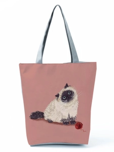 Close-up of pink tote bag showing cute cartoon cat print and canvas texture details