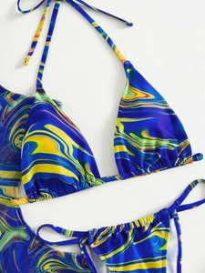 Detailed flat lay of three-piece bikini set with blue marble print and mesh sarong cover-up