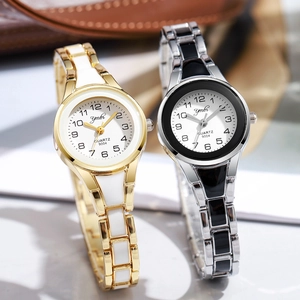 Detail view of gold and silver quartz watches with ceramic link metal bracelets