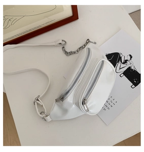 Detailed shot of white PU leather waist bag with silver chain and dual zipper design