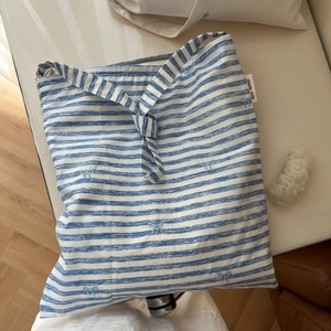 Détail du sac cabas en coton à rayures bleues et blanches avec nœud brodé