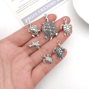 Detailed close-up of antique silver sea turtle pendants for DIY jewelry making