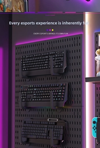 Detail of black pegboard with U-shaped brackets displaying mechanical gaming keyboards