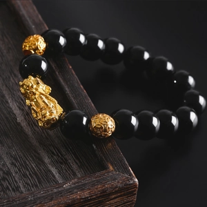 Men's obsidian-style bracelet featuring golden Pi Xiu and engraved mantra prayer beads
