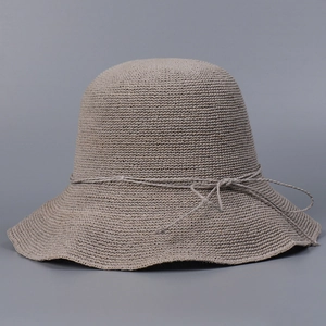 Close-up of the beige hand-crocheted sun hat with mesh texture and bow detail