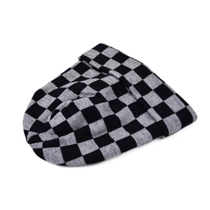 Detailed view of grey and black checkered knit beanie with a folded cuff and soft texture