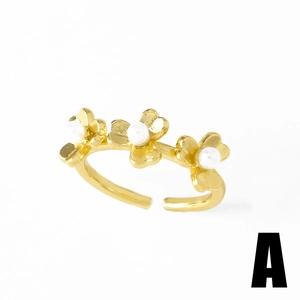 Gold-plated open ring with three flower motifs and white faux pearls on a white background