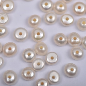 Dettaglio di perle d'acqua dolce da 7 mm con foro centrale per creazione gioielli fai da te