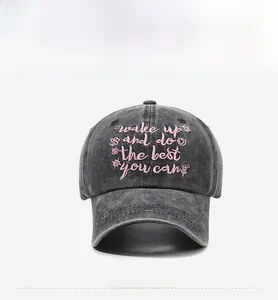 Detail of pink embroidered motivational text on a grey washed cotton baseball cap