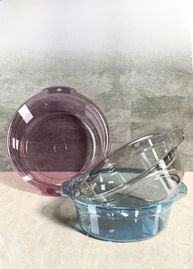 Close-up of translucent plastic washbasins with side handles in purple and blue tones