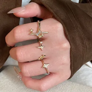 Three-piece set of gold starburst rings with zircon stones on brown wool background