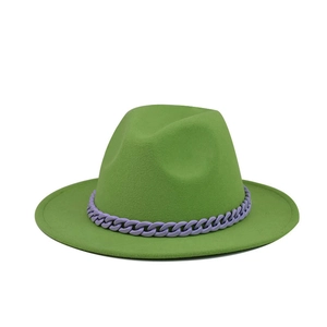 Detail of green wool fedora hat featuring a bold purple decorative chain accessory