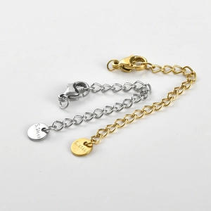 Detail of gold and silver stainless steel extension chains with lobster clasps and S.Steel tags