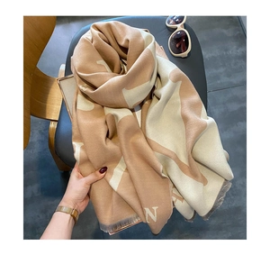 Détail d'une écharpe beige au toucher cachemire avec grand motif N et franges fines