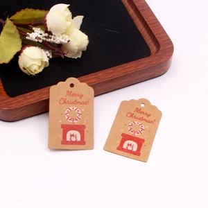 Detail of kraft paper Christmas gift tags with red Merry Christmas text and wreath