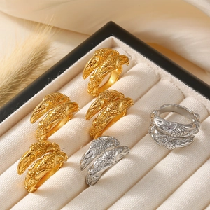 Gothic claw rings set in gold and silver finish with textured scales on jewelry display