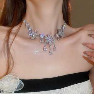 Detail view of silver floral necklace with sparkling zircon droplets on a model