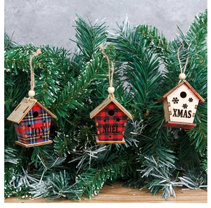 Detail of wooden birdhouse Christmas ornaments with plaid patterns hanging on a pine tree