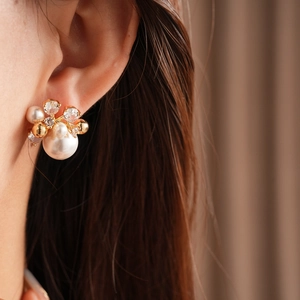 Macro shot of French luxury flower earrings with gold plating, pearls, and zircons