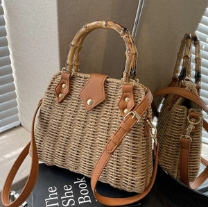 Straw basket bag with bamboo handle and leather strap for a vacation style look