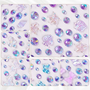 Macro shot of 3D mixed nail charms with aurora butterflies and shells on white silk