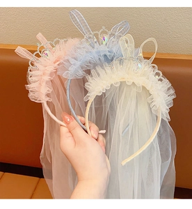 Detailed view of pink, blue, and white princess crown headbands with tulle mesh veils