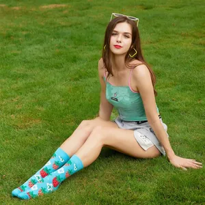 Close-up of bright blue cotton crew socks featuring red strawberry and white cross patterns