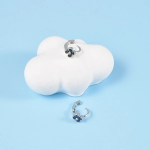 Silver flower earrings with blue and black zircon stones on cloud-shaped display