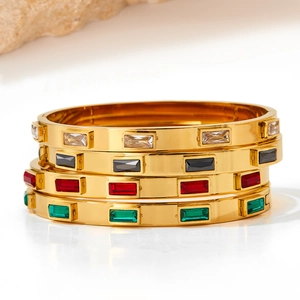 Set of four gold stainless steel bracelets with white, black, red, and green cubic zirconia