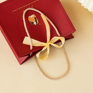 Red paper gift bag for teachers with golden handles and yellow satin bow decoration