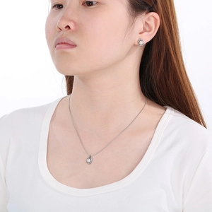 Silver steel O-chain necklace and earrings set with shell pearls on female model