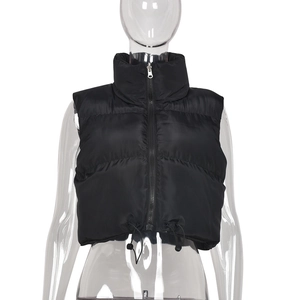 Detail of black crop puffer vest showing stand collar, zipper and adjustable drawstring hem