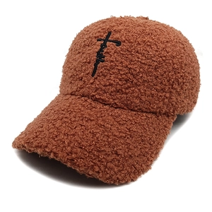 Détail de la casquette en polaire peluche marron avec broderie croix faith noire