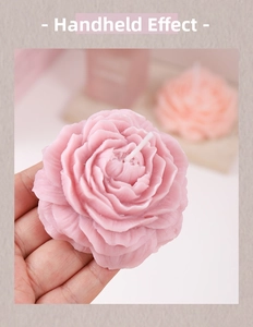 Macro shot of hand-held peony scented candle with realistic light pink wax petals