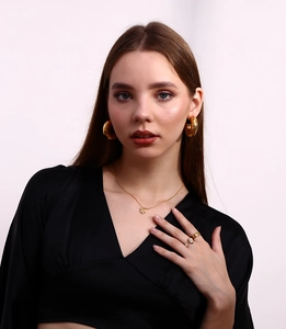Detailed view of 18K gold plated jewelry set including floral necklace and hoop earrings