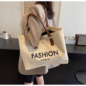 Seitenansicht der großen Canvas-Tragetasche mit braunen Trägern und Fashion Paris Schrift