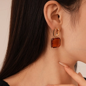 Boucles d'oreilles vintage en cristal ambré et cadre doré portées par un mannequin chic