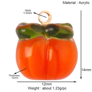 Detailed view of an orange acrylic persimmon fruit pendant with golden jump ring