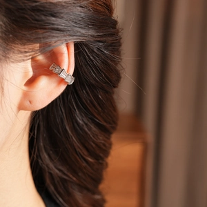 Detailed view of silver snake-shaped ear cuff with zircons worn on ear for women