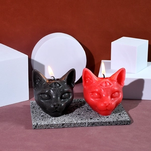 Three-eyed cat head candles in black and red colors for Halloween decor and ambiance